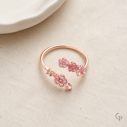 Complete rose-gold-color pink blossom bypass ring arranged on oatmeal linen