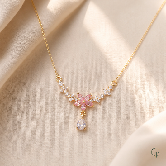 Pink blossom clear-stone drop necklace on warm ivory linen