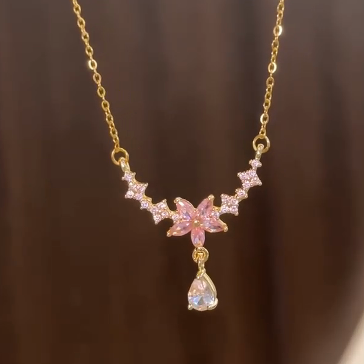 Close view of the six-petal pink blossom and clear-stone accents