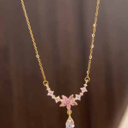 Front view of the pink blossom necklace and dangling clear drop