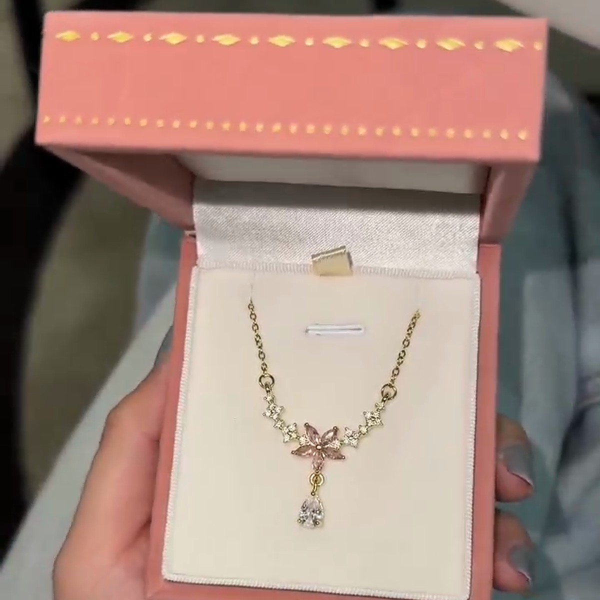 Pink blossom drop necklace displayed inside a pink jewelry box