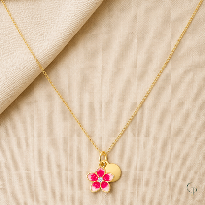 Pink blossom and disc pendant necklace arranged on warm oatmeal linen