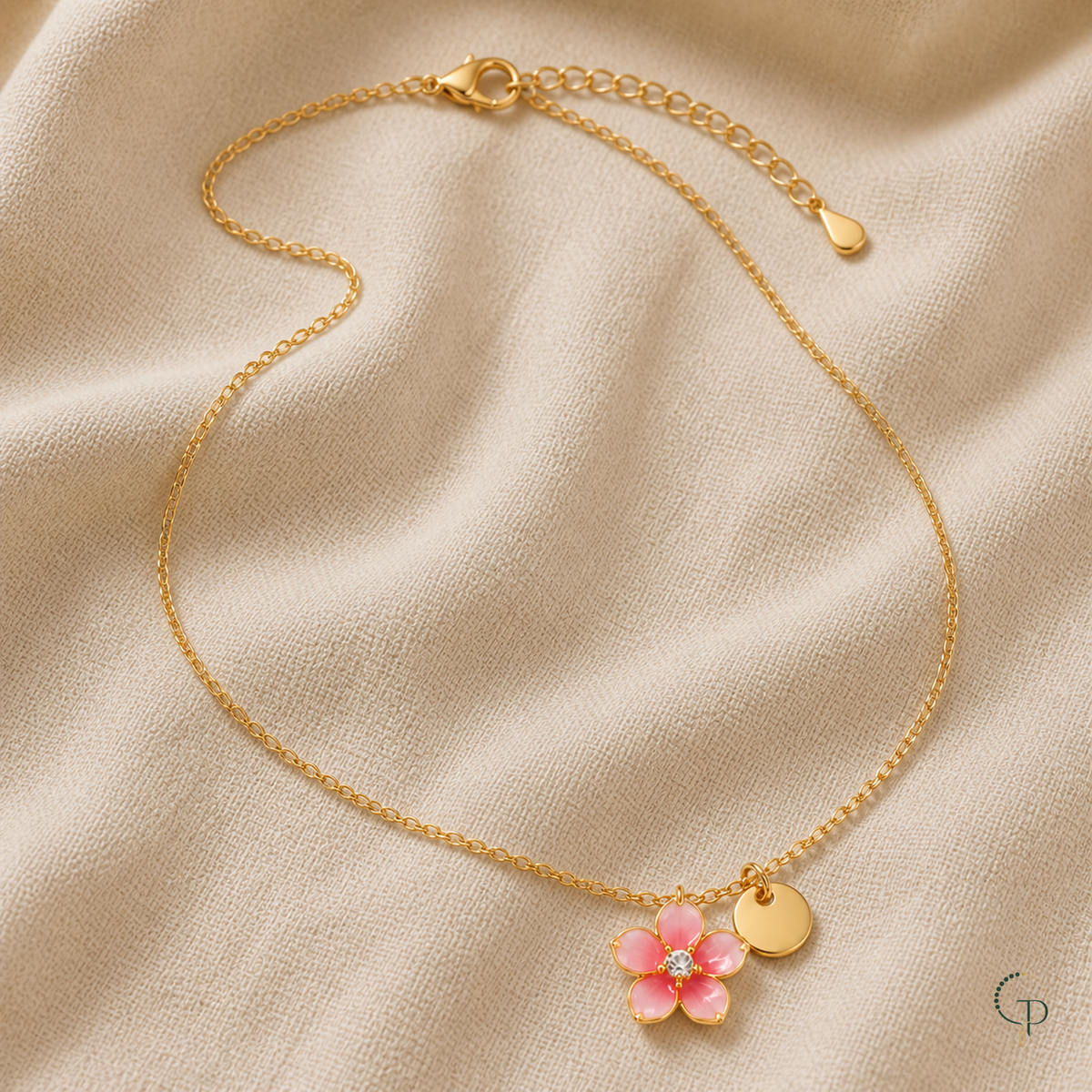 Detail of the necklace lobster clasp, extension links, flower pendant and round tag