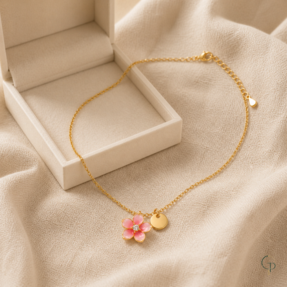 Pink blossom pendant necklace beside an unbranded ivory jewelry box