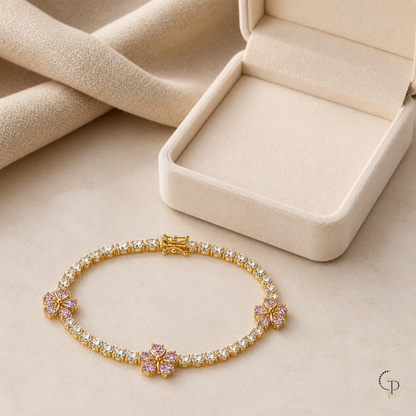 Pink blossom tennis-style bracelet beside an unbranded ivory jewelry box