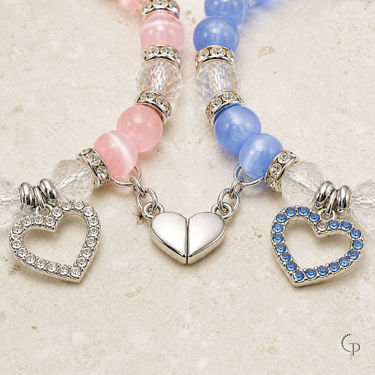 Close view of open-heart charms and connected magnetic heart on matching bracelets