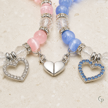 Close view of open-heart charms and connected magnetic heart on matching bracelets