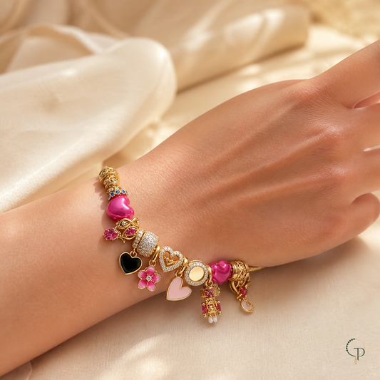 Gold-color pink heart multi-charm bracelet worn on a wrist