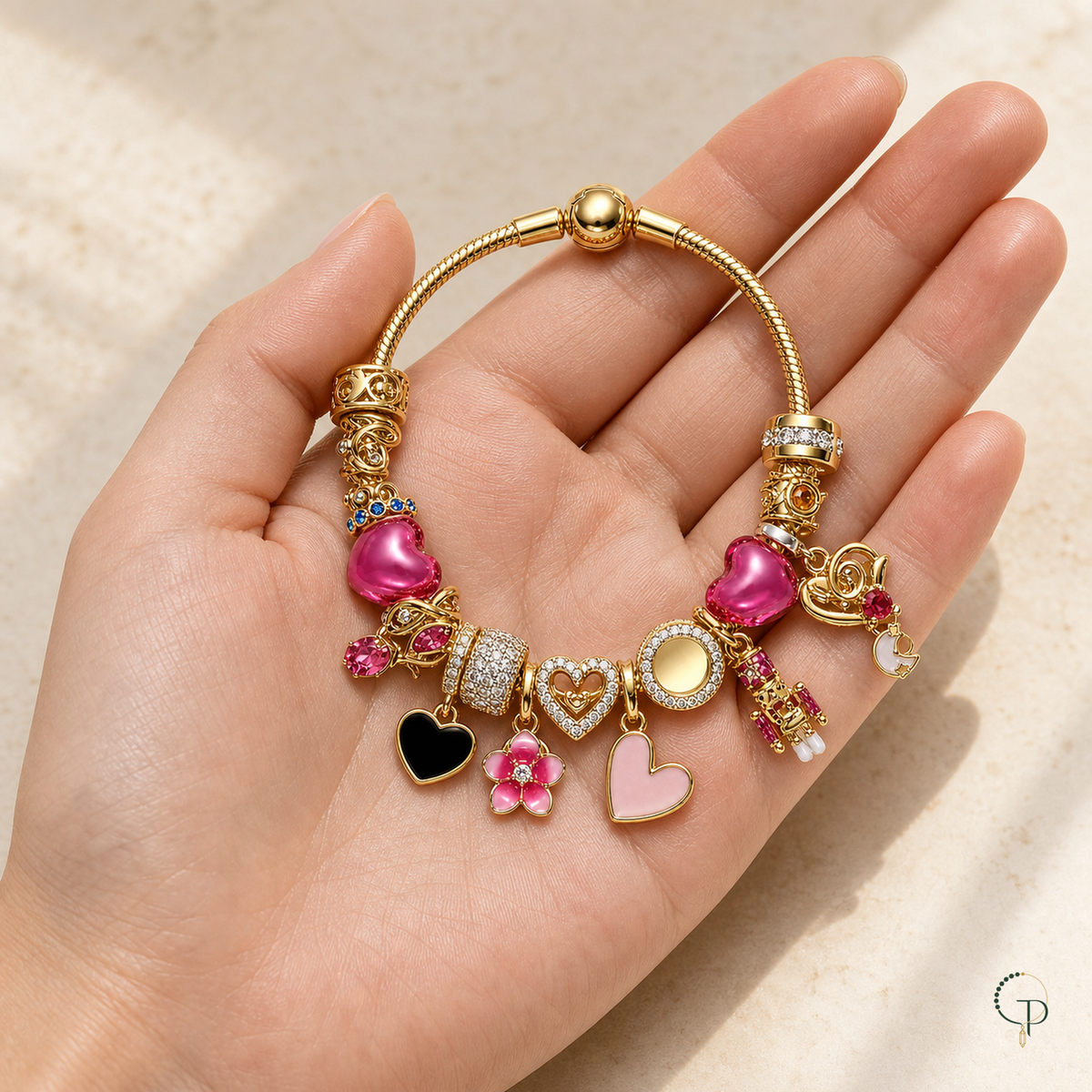 Gold-color multi-charm bracelet displayed across an open palm