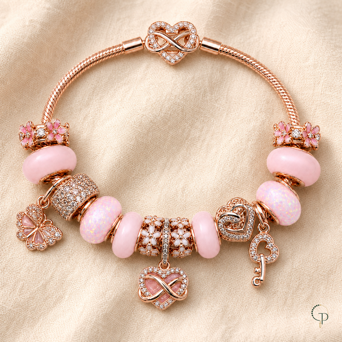 Complete pink rose-gold-color charm bracelet arranged on oatmeal linen