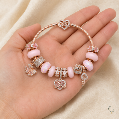 Pink blossom and infinity charm bracelet displayed across an open palm