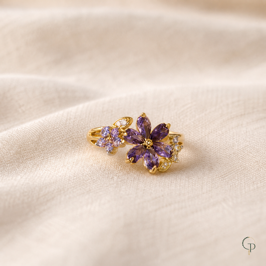 Gold-color purple marquise-stone floral cluster ring on warm ivory linen
