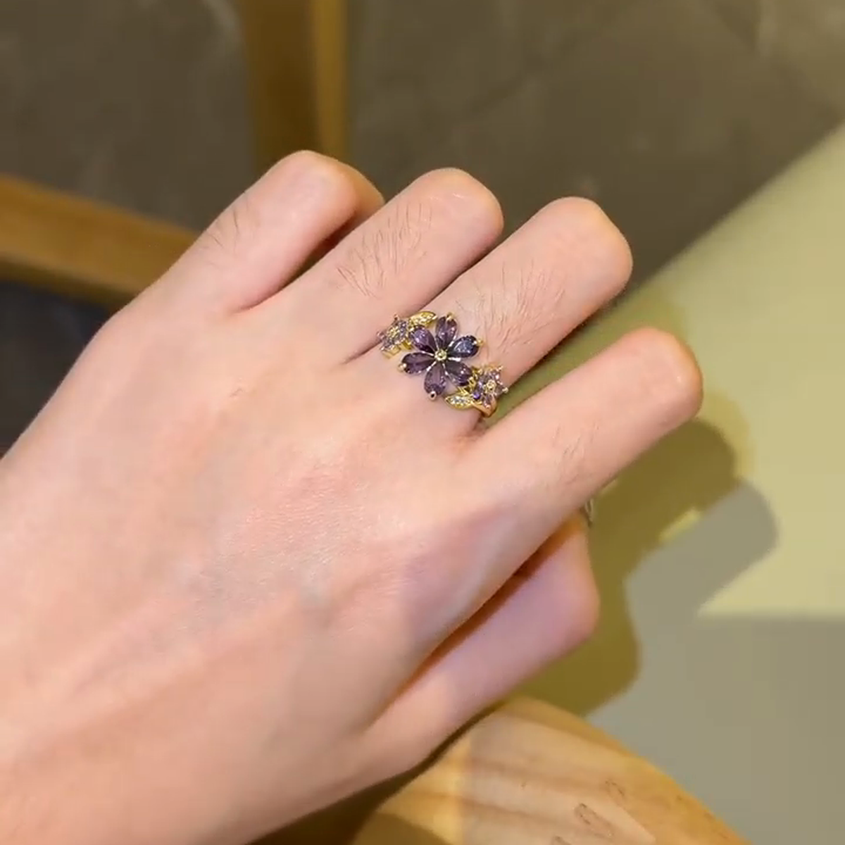 Purple floral cluster statement ring worn alone on the hand