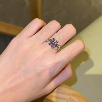 Purple floral cluster statement ring worn alone on the hand
