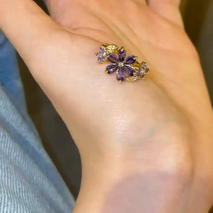 Purple flower cluster ring resting on a palm for visual scale