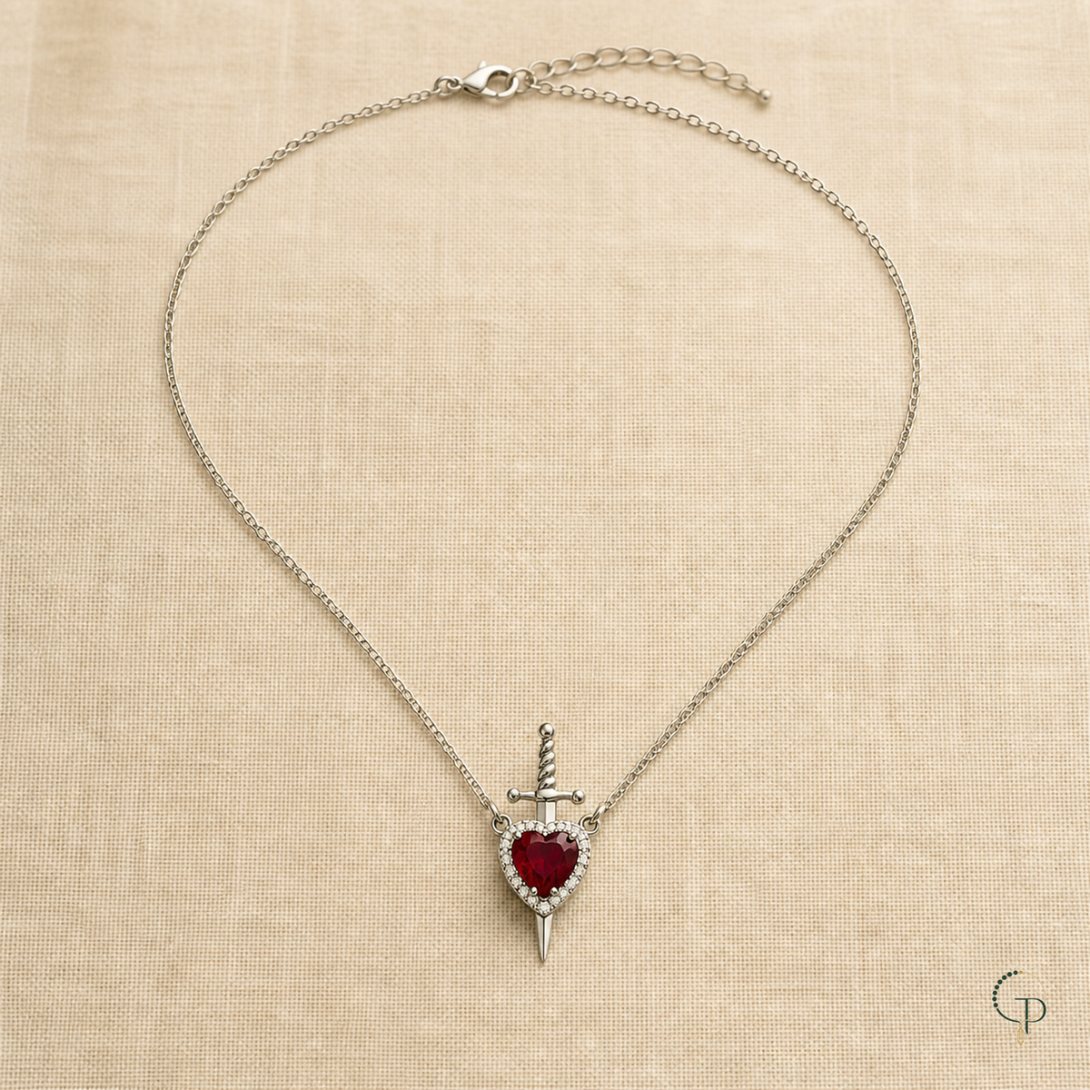 Full silver-color oval-link necklace with red heart sword pendant on oatmeal linen