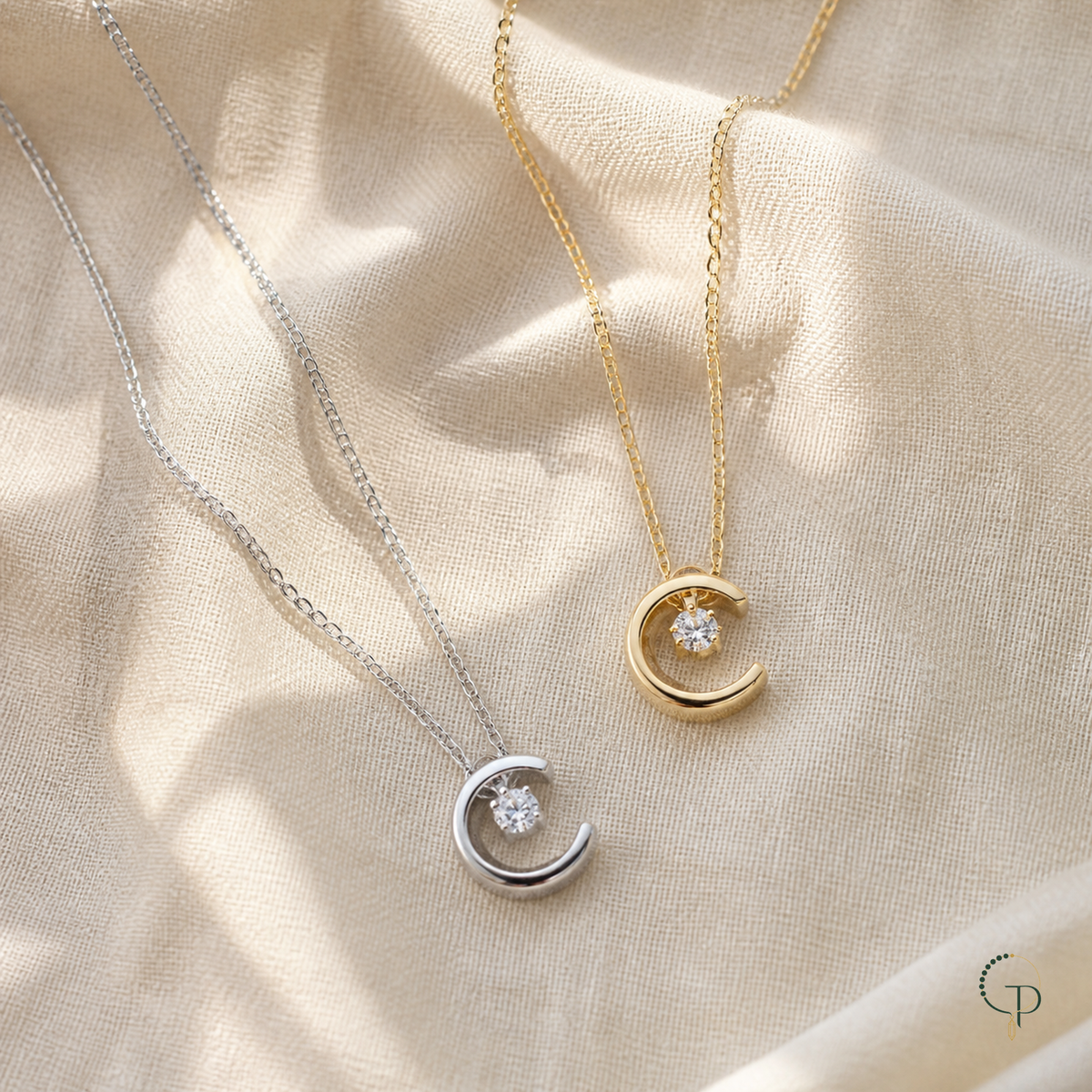 Gold and silver crescent moon crystal pendant necklaces on warm ivory linen | PureNoi