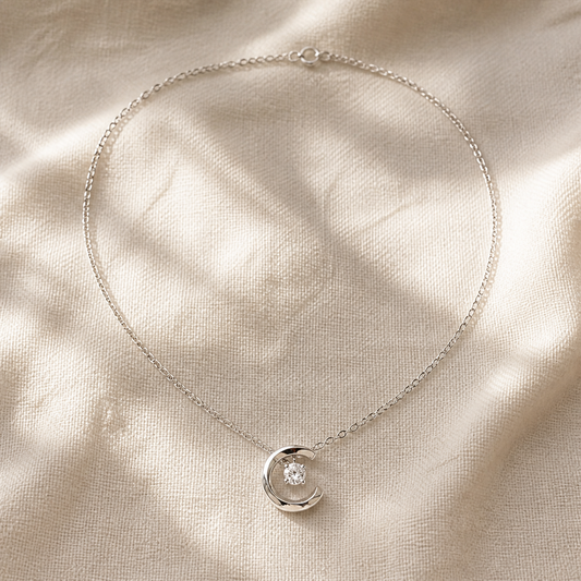 Silver-color crescent moon necklace with suspended round crystal