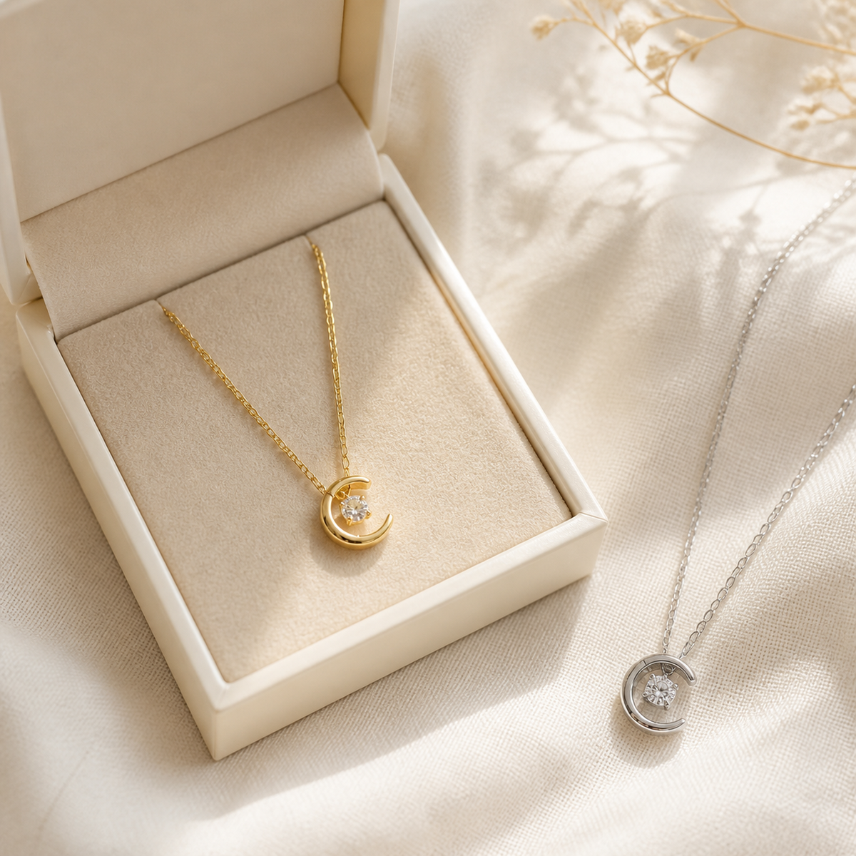 Gold and silver crescent moon necklaces with an ivory jewelry box