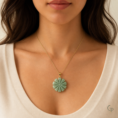 Seafoam-green sunburst pendant necklace styled on a cream neckline