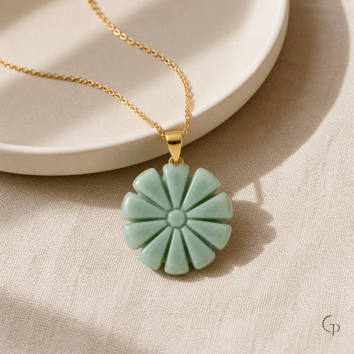Seafoam sunburst pendant necklace styled beside an ivory ceramic dish