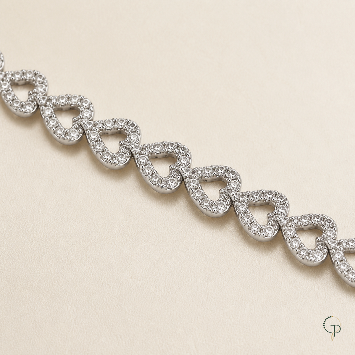 Macro view of repeating pave-like open heart necklace links on warm ivory