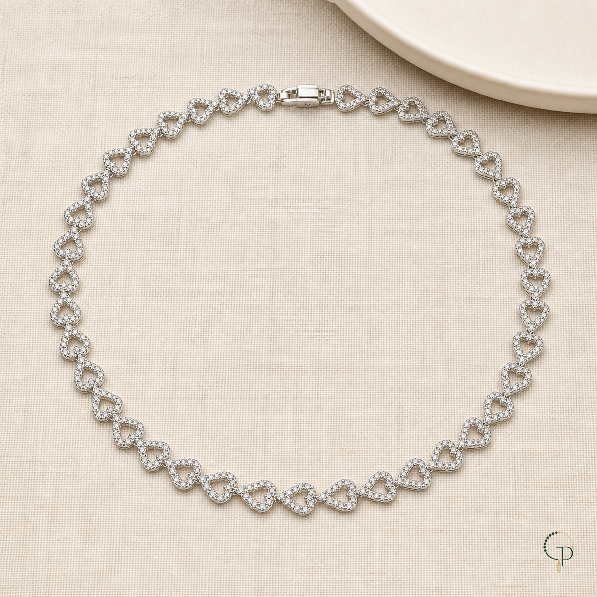 Full silver-color heart link collar necklace arranged on oatmeal linen