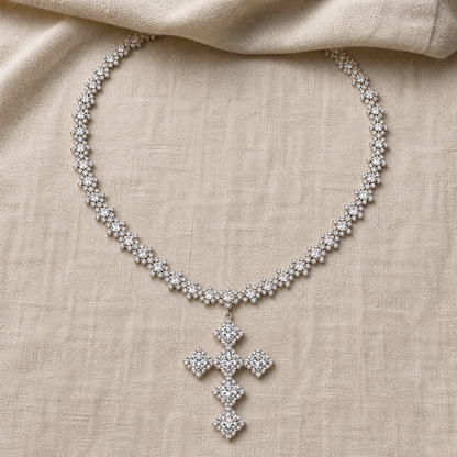 Full silver-color cross necklace laid flat on neutral linen