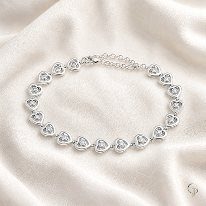 Single-crystal heart link bracelet arranged on ivory linen