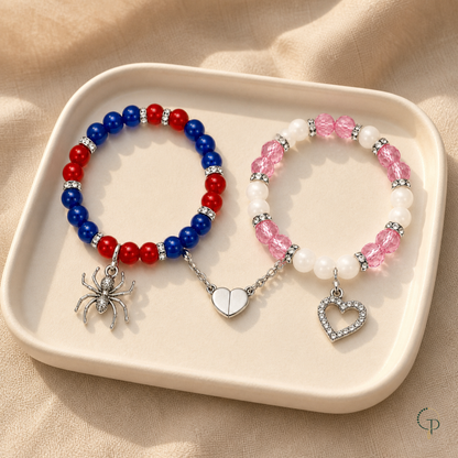 Spider and heart magnetic bracelet pair displayed on an ivory tray