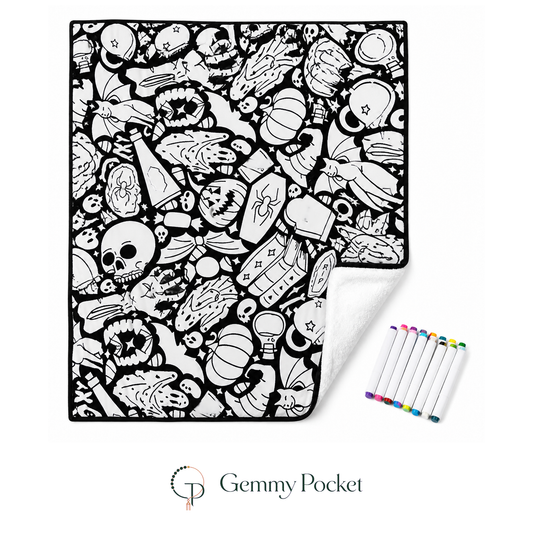 Spooky doodle coloring blanket with markers on a white studio background