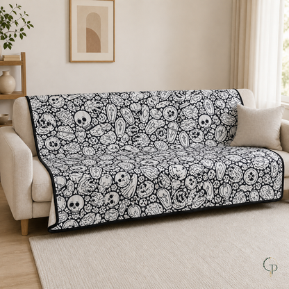 Large spooky doodle coloring blanket spread across a neutral living-room sofa