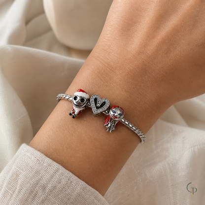 Skeleton figures and layered black heart silver-color charm bracelet worn on wrist