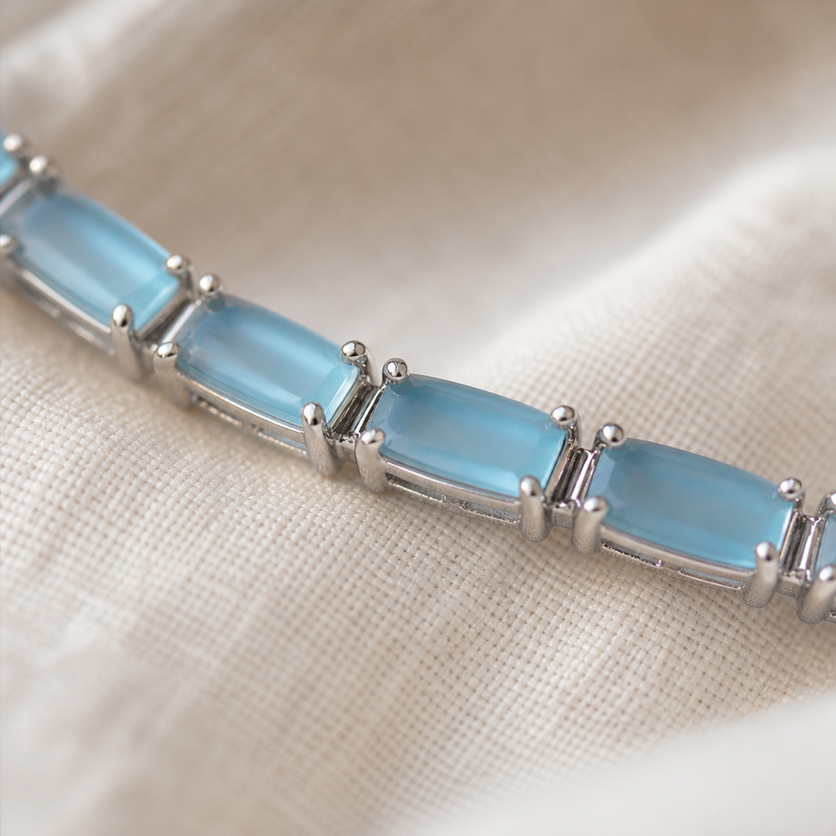 Close-up of light blue rectangular stones and silver-color prong settings