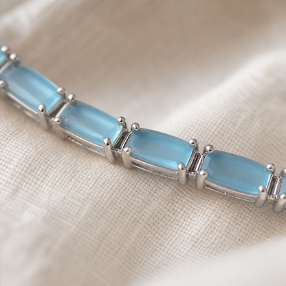 Close-up of light blue rectangular stones and silver-color prong settings