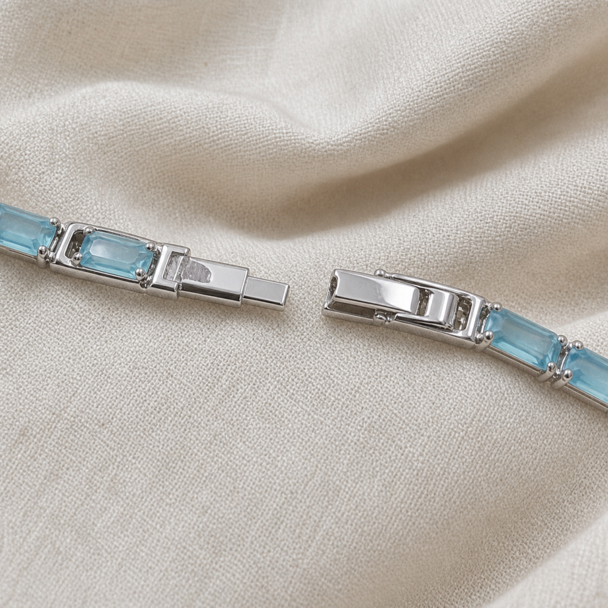 Close-up of clasp and linked setting on light blue tennis bracelet
