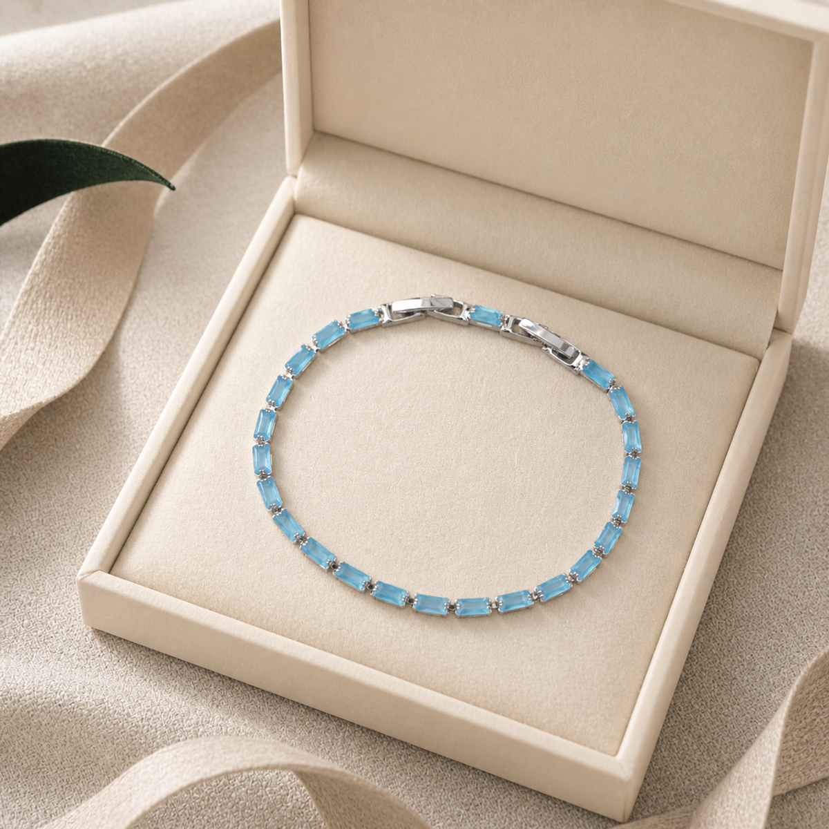 Light blue tennis bracelet presented in an ivory jewelry box