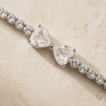 Close view of the two heart-shaped clear stones and round stone links in the silver-color bracelet