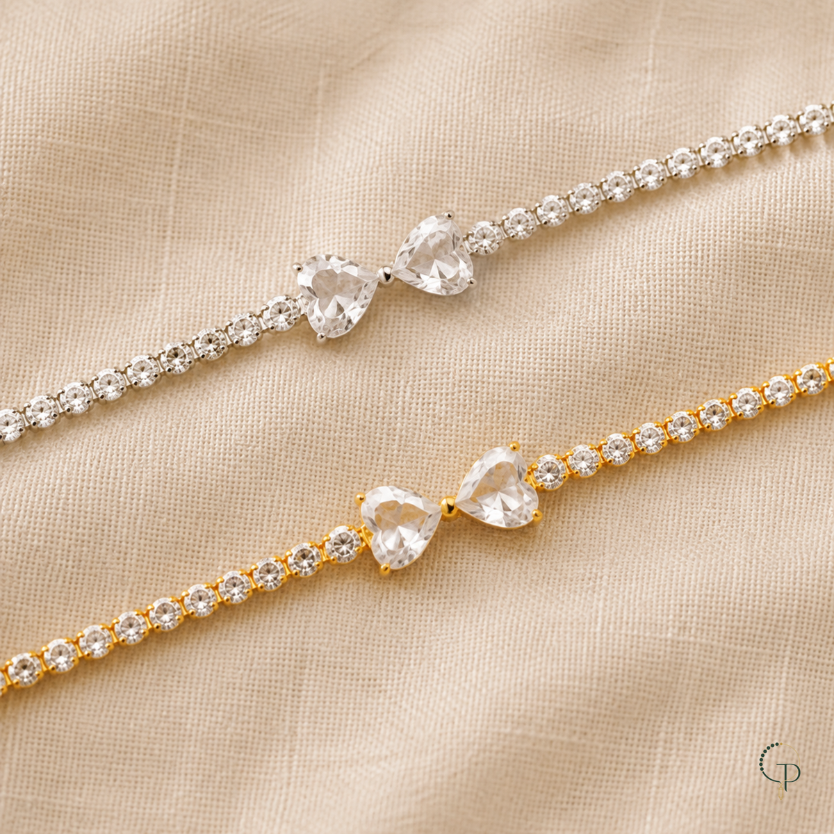 Silver-color and gold-color twin heart bow tennis bracelet options displayed separately on linen
