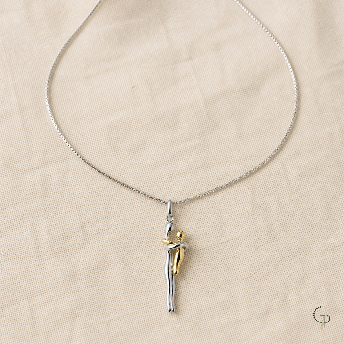Fine silver-color necklace with two-tone figure pendant arranged on oatmeal linen