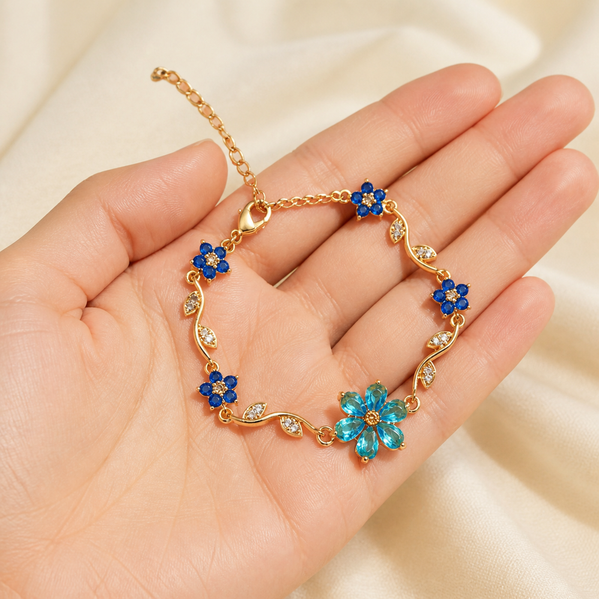 Hand holding the blue floral bracelet for visual scale