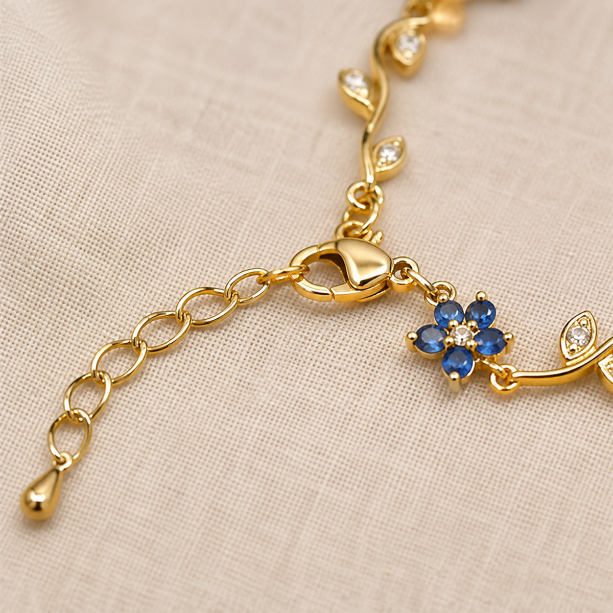 Detail of the lobster clasp, extension chain and small blue flower