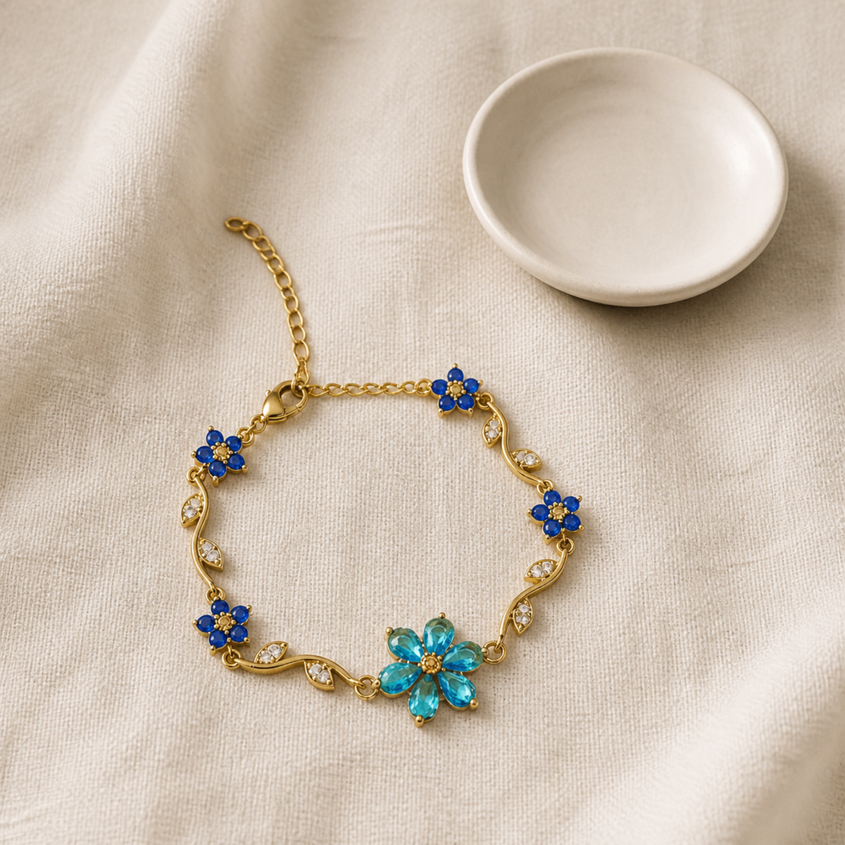 Blue floral vine bracelet beside an ivory ceramic dish