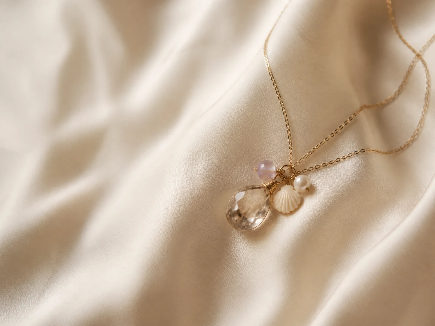 Delicate Gemmy Pocket necklace arranged on ivory linen